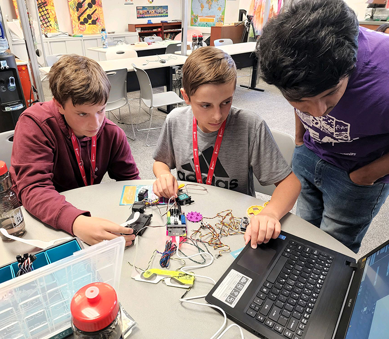 Students wiring and testing on a laptop computer.