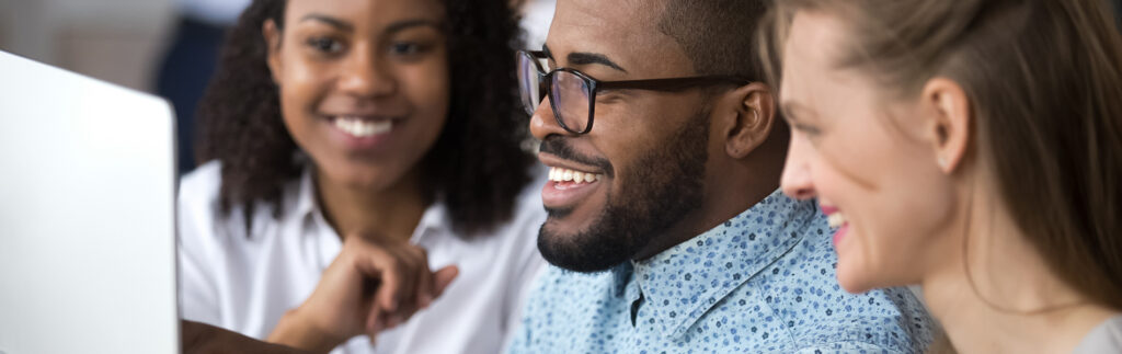 Multi ethnic colleagues mates work together using pc. African mentor explain application help to interns at group meeting. Coaching, teamwork concept. Horizontal photo banner