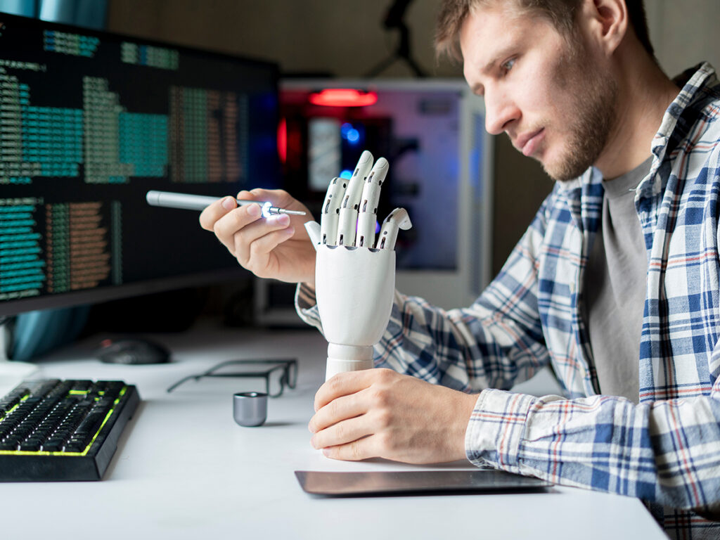male engineer working on the development of robotic arm or hand, new modern technology concept