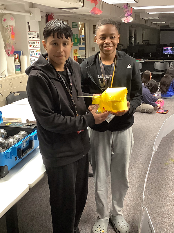 Two students in the NIU STEAM lab showing off their project