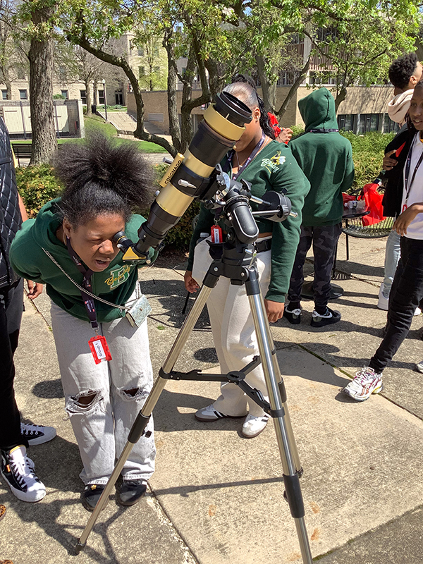 A student looks through a telescope